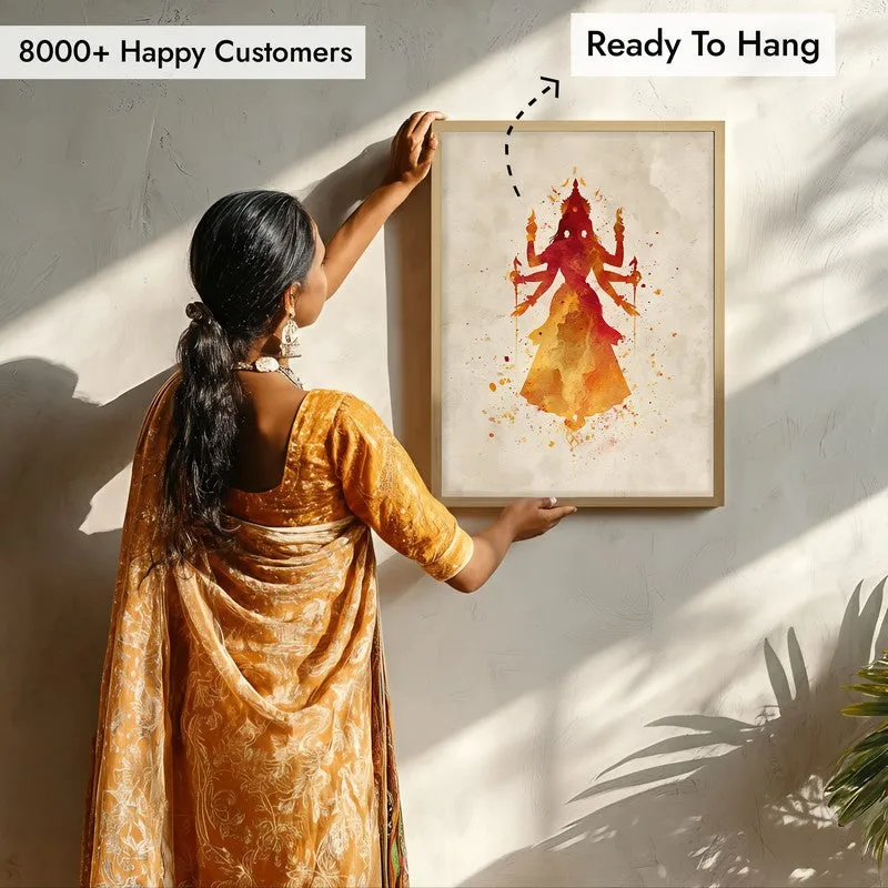 Person hanging framed Durga wall art on a sunlit wall