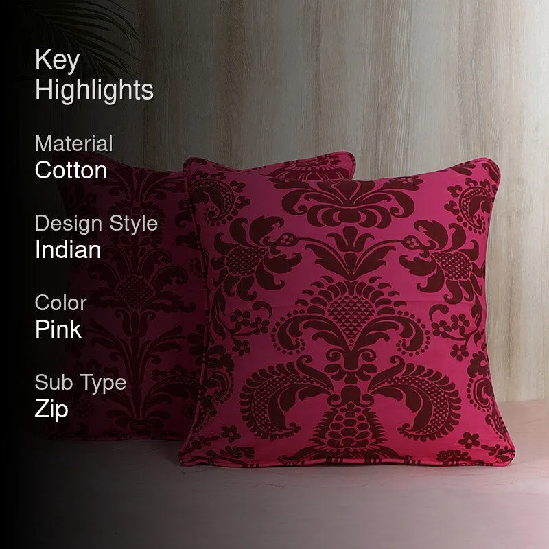 Two ornate pink and brown cushion covers shown against a warm wood backdrop.