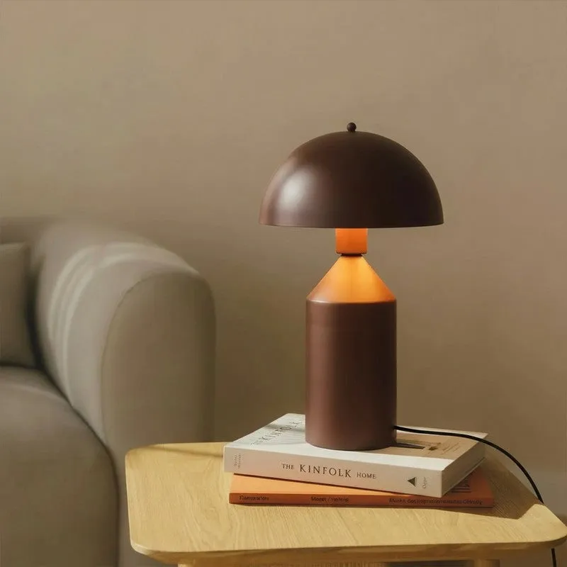 Brown table lamp glowing beside a sofa on a wooden side table