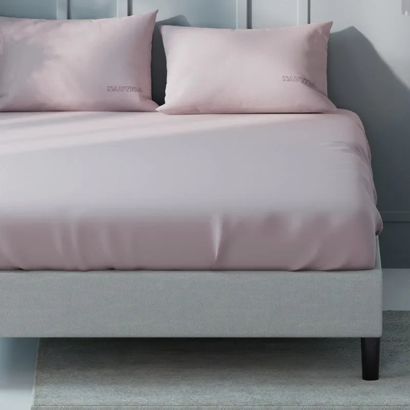 Close view of pink solid bedsheet draped over a King bed