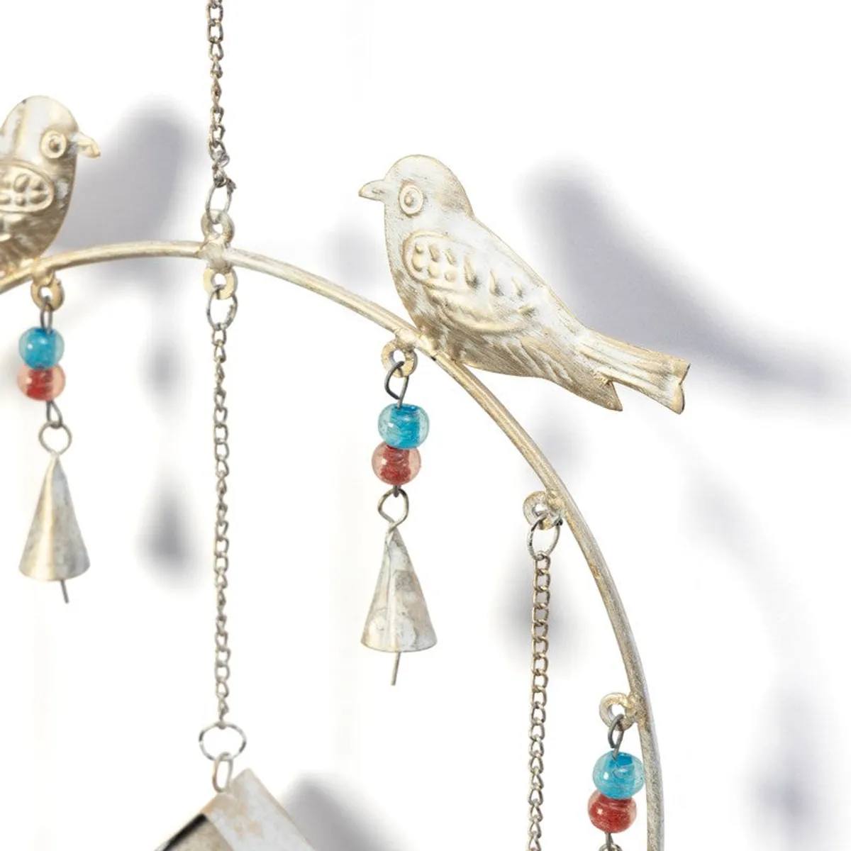 Close-up of a white bird-shaped windchime with colourful beads and bells