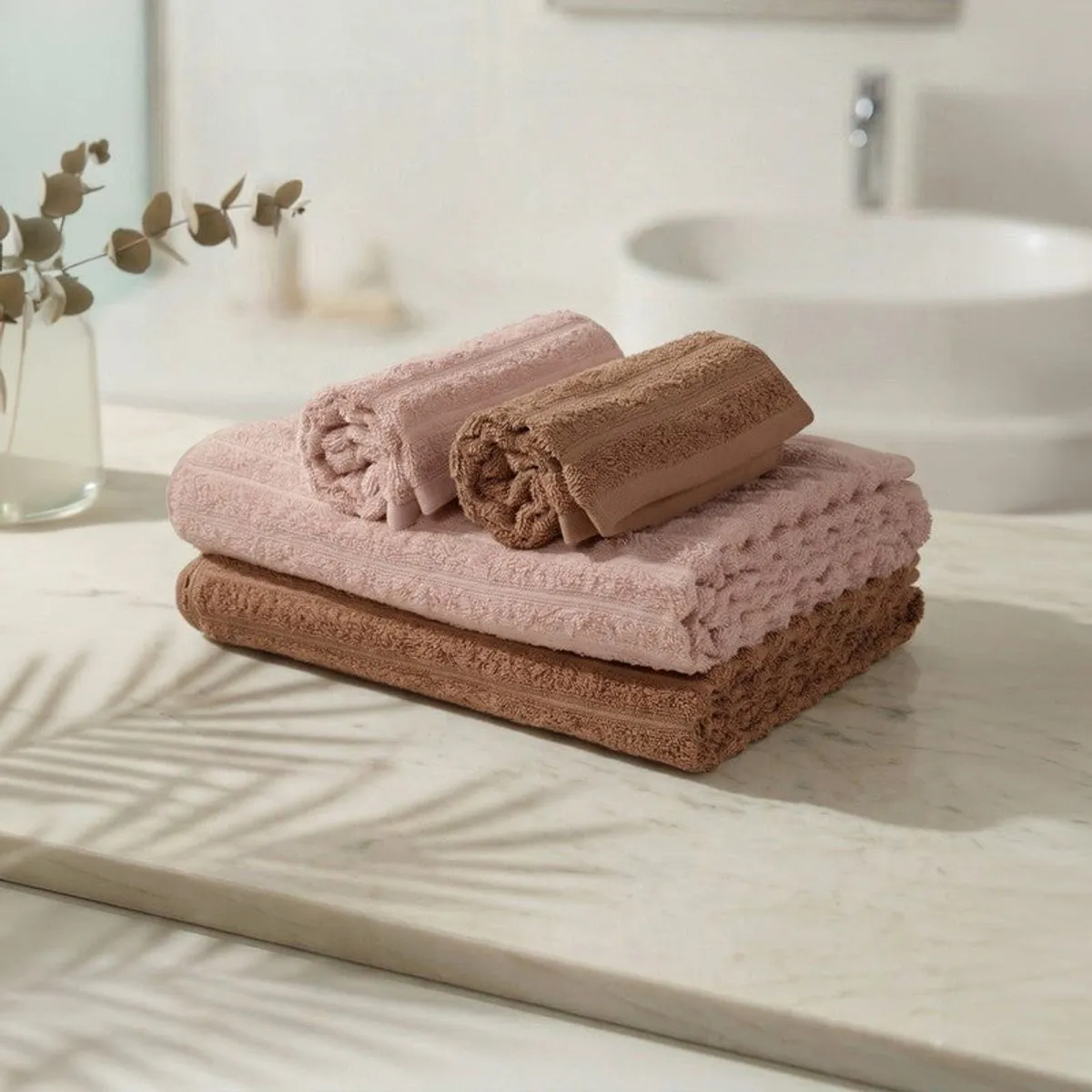 Folded peach and brown bath and hand towels on a bathroom counter