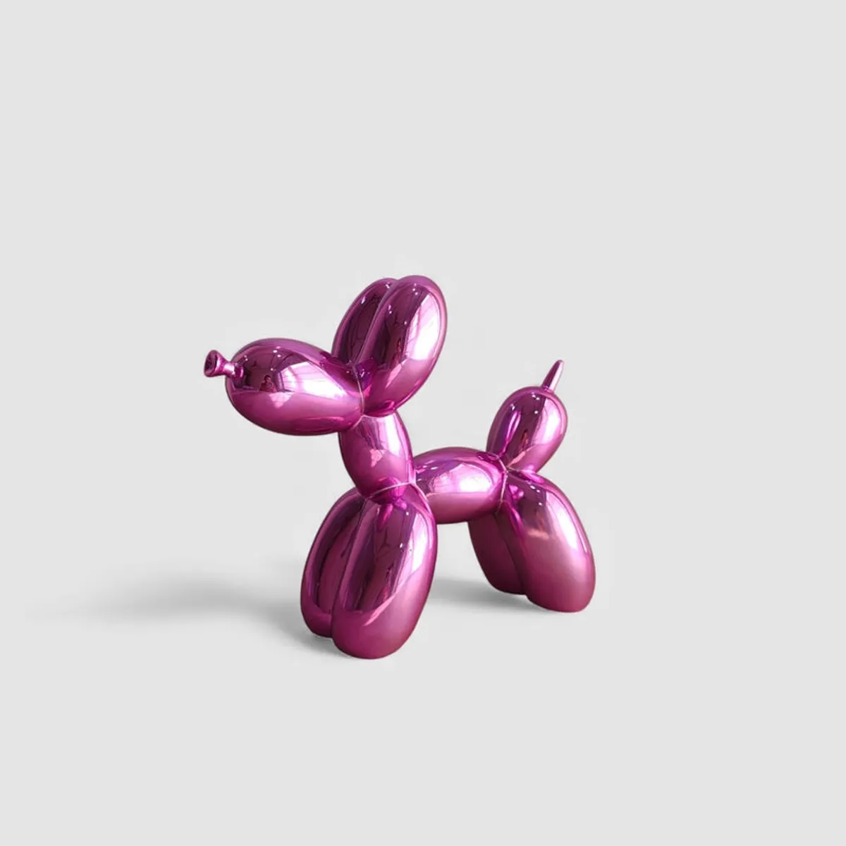 Three-quarter view of a glossy pink balloon dog showpiece on a plain light background.