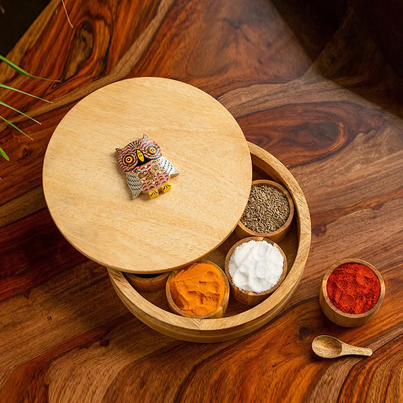 Open round wooden masala box showing spice containers and owl lid detail