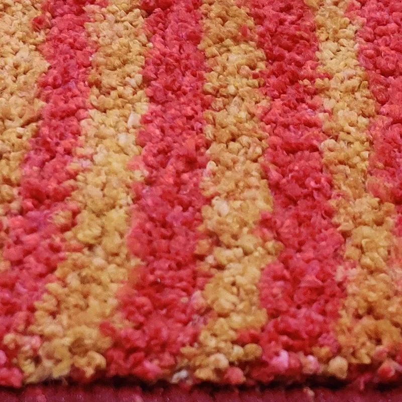 Close-up of the rug's soft, textured orange and red pile