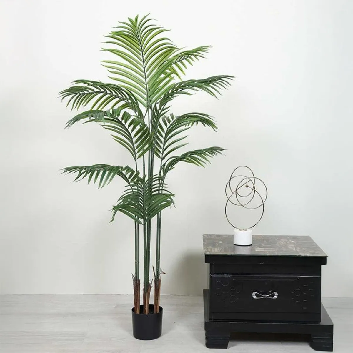 Tall green artificial Arica palm with feathery fronds in a black pot