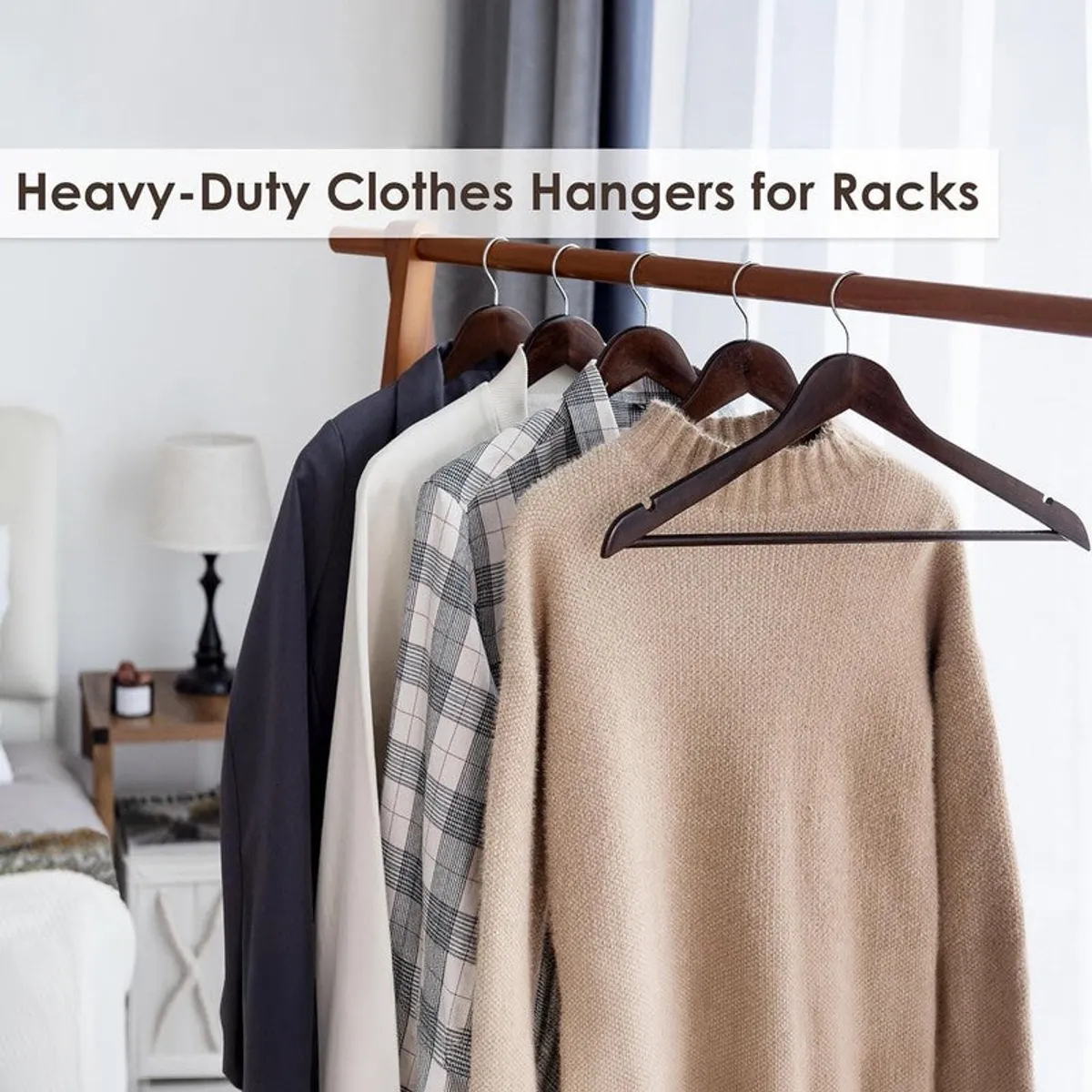 Brown wooden hangers displaying shirts and knitwear on a clothing rack
