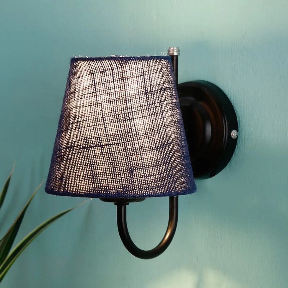 Close-up of blue jute wall lamp with black round wall base