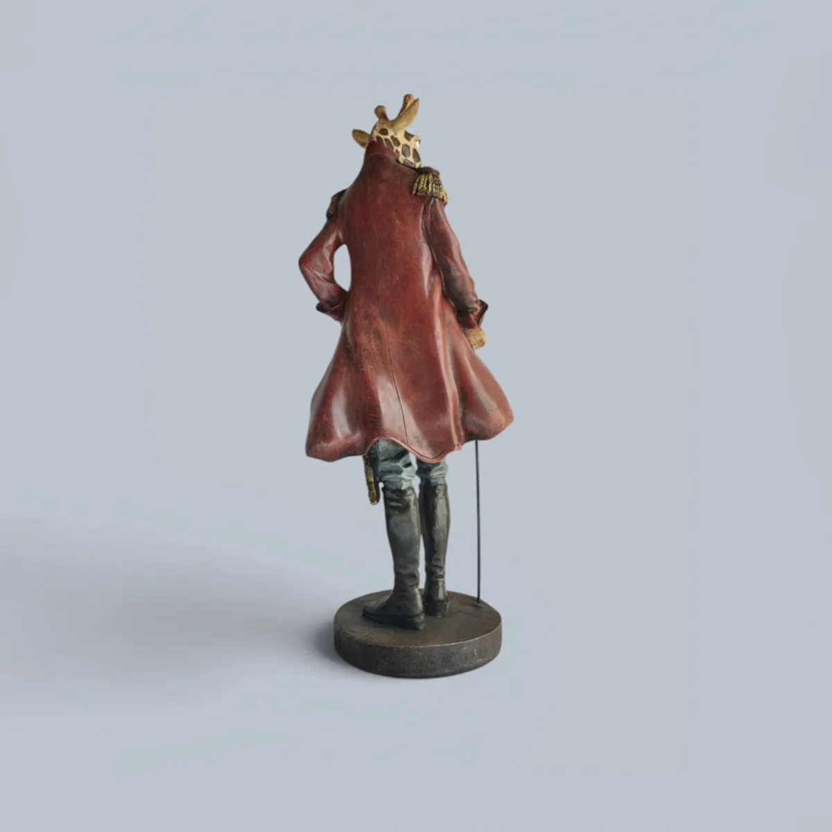 Rear view of the figurine on a round base against a plain light background.