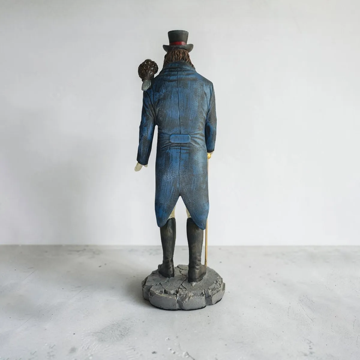 Back view of the rooster gentleman showpiece with long blue coat and base