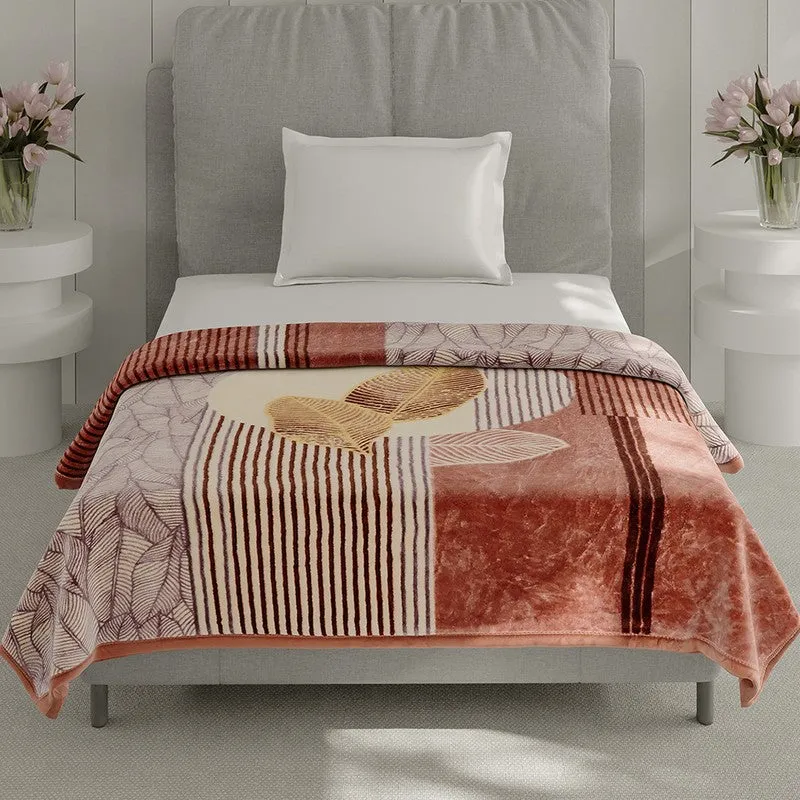Printed brown blanket spread across a bed with abstract stripes and leaf motifs