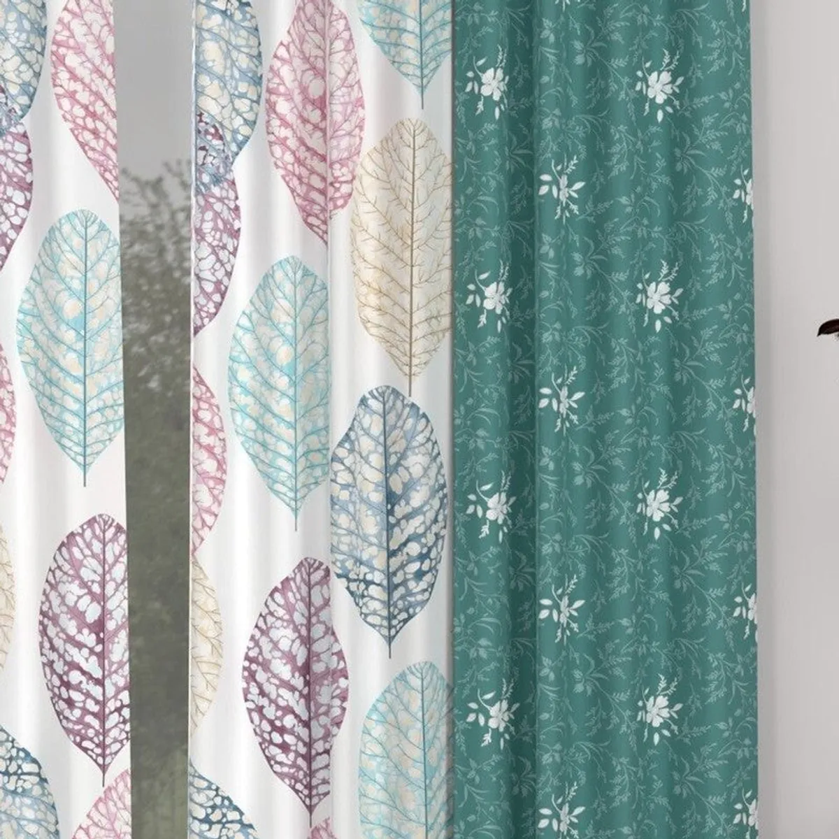 Close-up of pastel leaf motifs on white and teal curtain panels