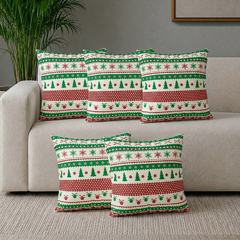 Five festive cushion covers arranged on a light-coloured sofa