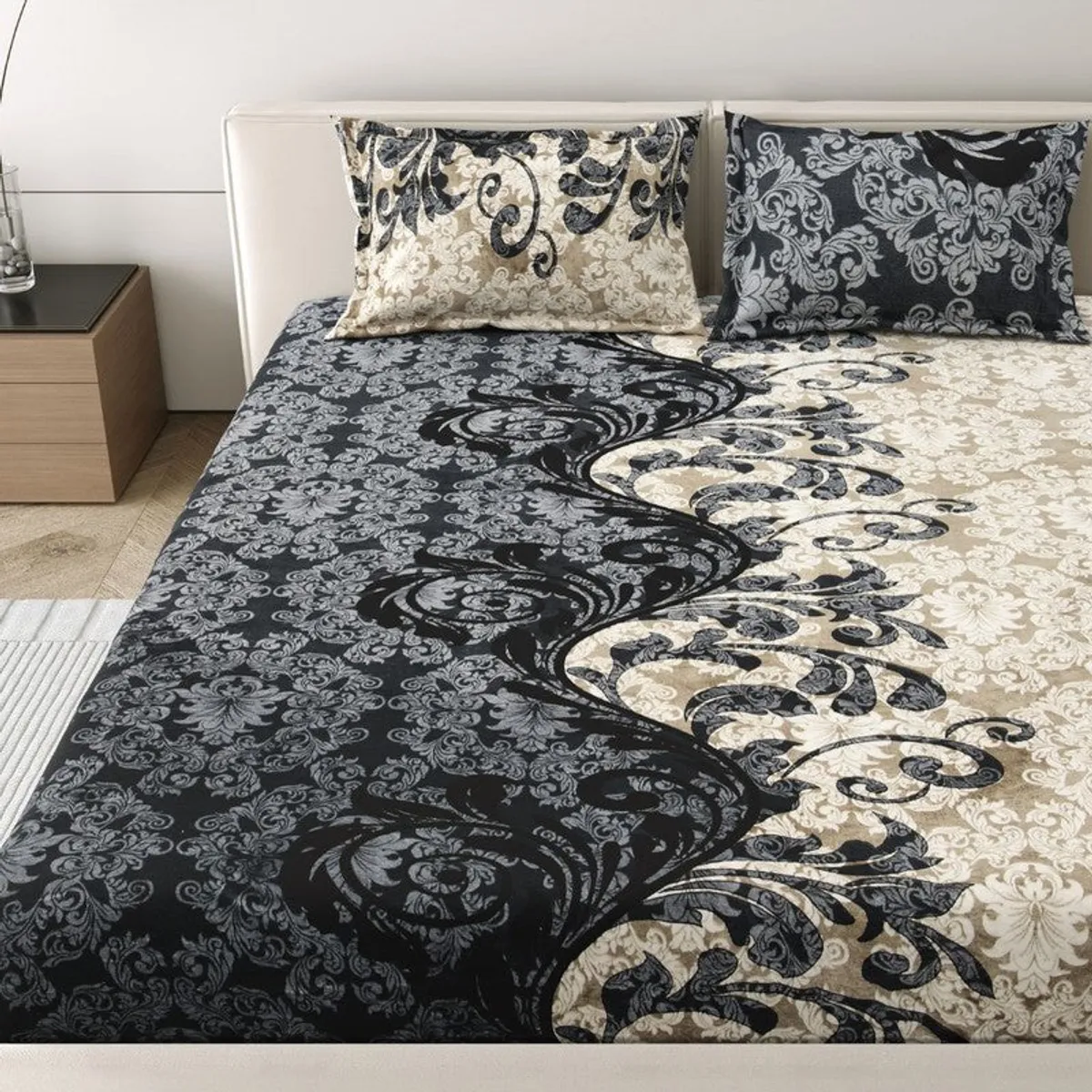 Detailed view of black and beige floral bedsheet spread across a bed