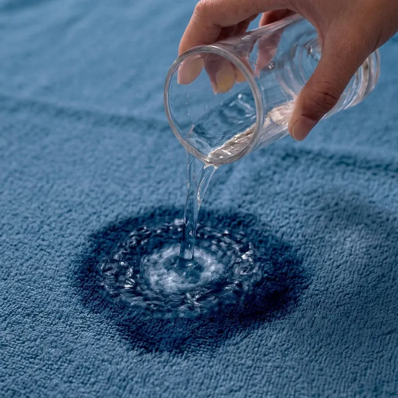 Water being poured onto a blue towel surface