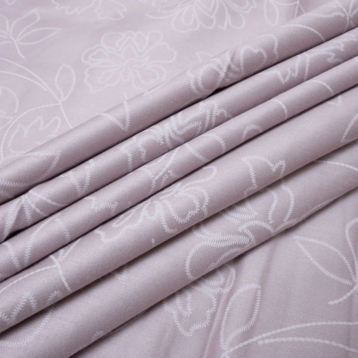 Folded soft pink-lavender floral cotton fabric showing its fine surface
