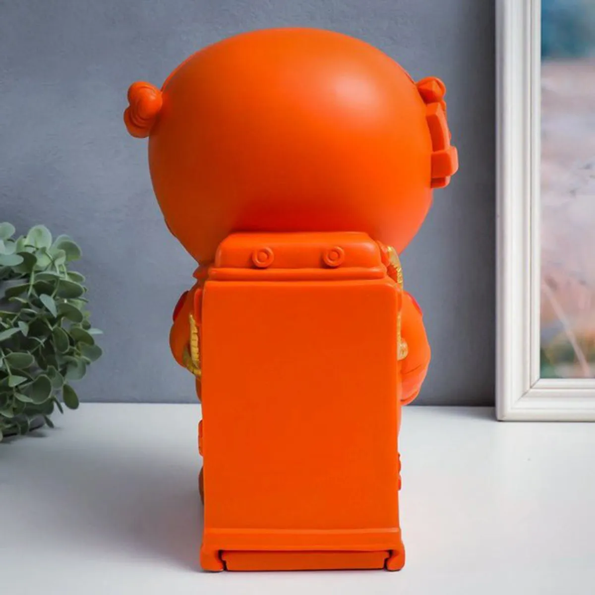 Back view of the orange astronaut showpiece with storage compartment