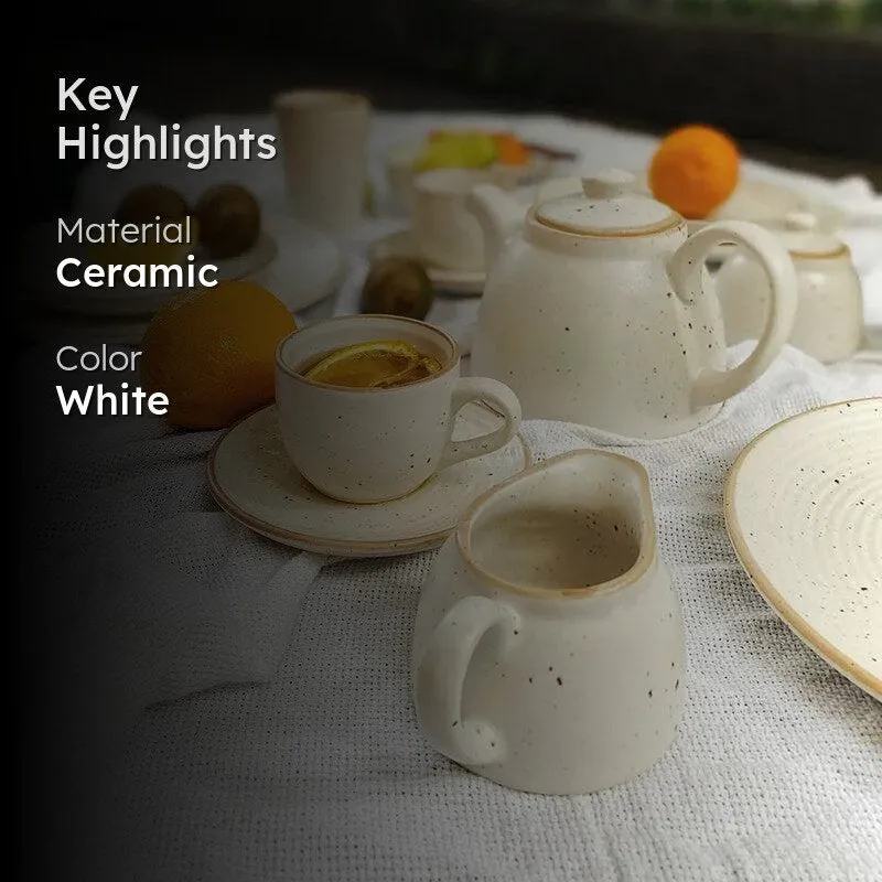 White speckled ceramic tea set with teapot, cup and milk pot