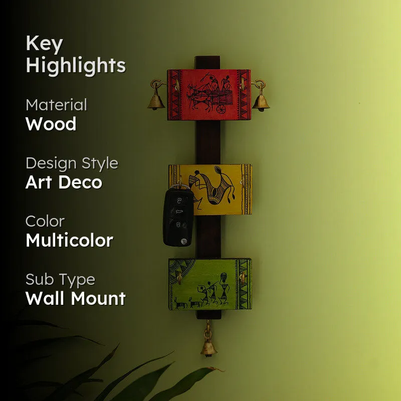 Lifestyle view of the vibrant Warli key hook displayed on a green wall.