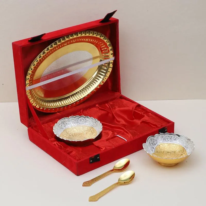 Two ornate dessert bowls and gold spoons arranged beside a red presentation case