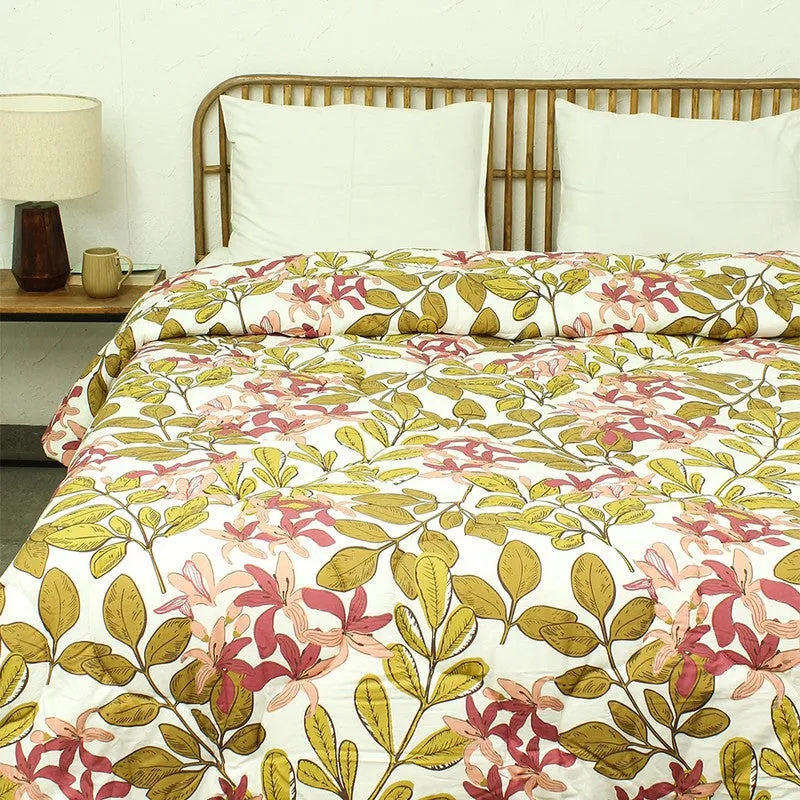 Close view of the pink and olive green floral comforter on a bed