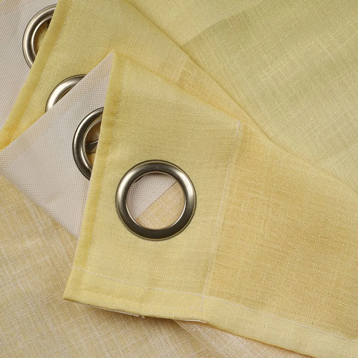 Close-up of yellow curtain fabric and metal eyelet ring