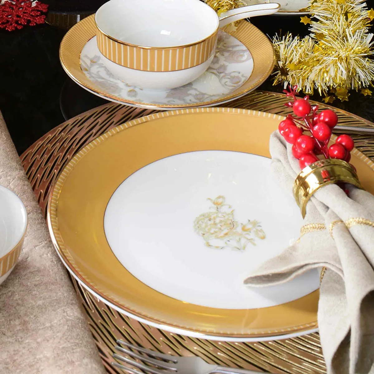 Festive table setting with mustard and gold plates, bowls and an oval platter