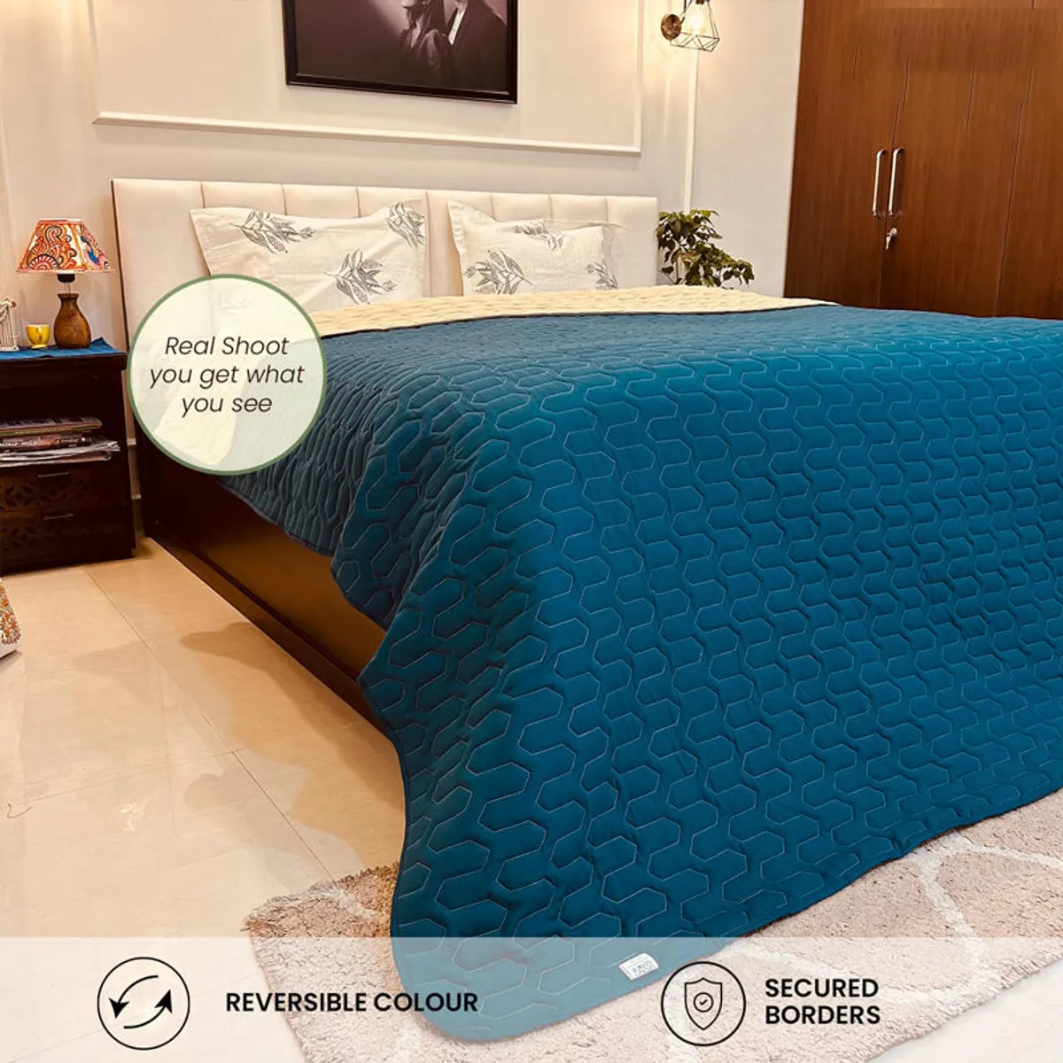 Teal comforter on a bed with a visible beige reversible side.