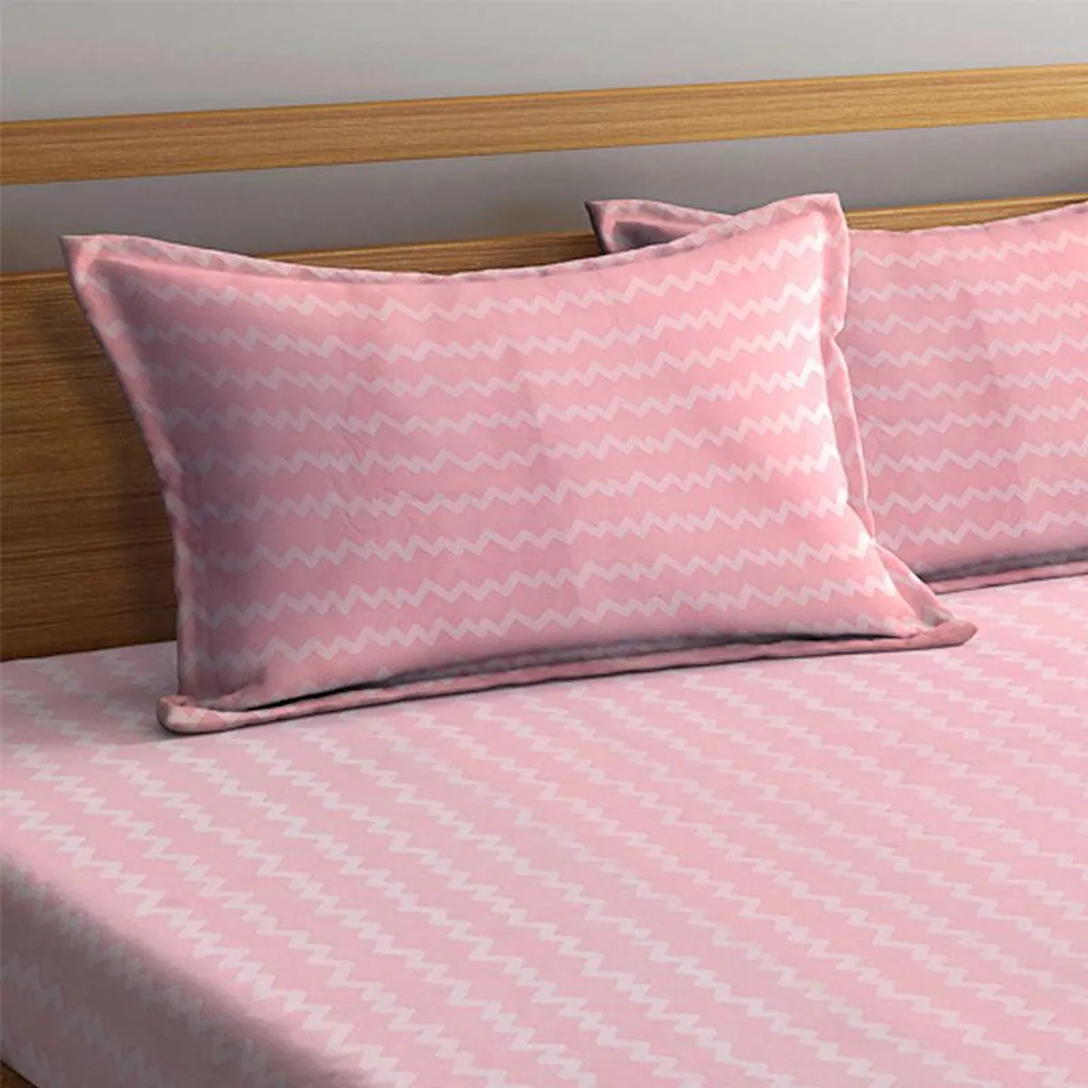 Close-up of a pink zigzag pillow cover styled on the bed