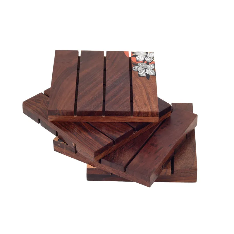 Stack of brown wooden coasters with a floral corner detail on a white background