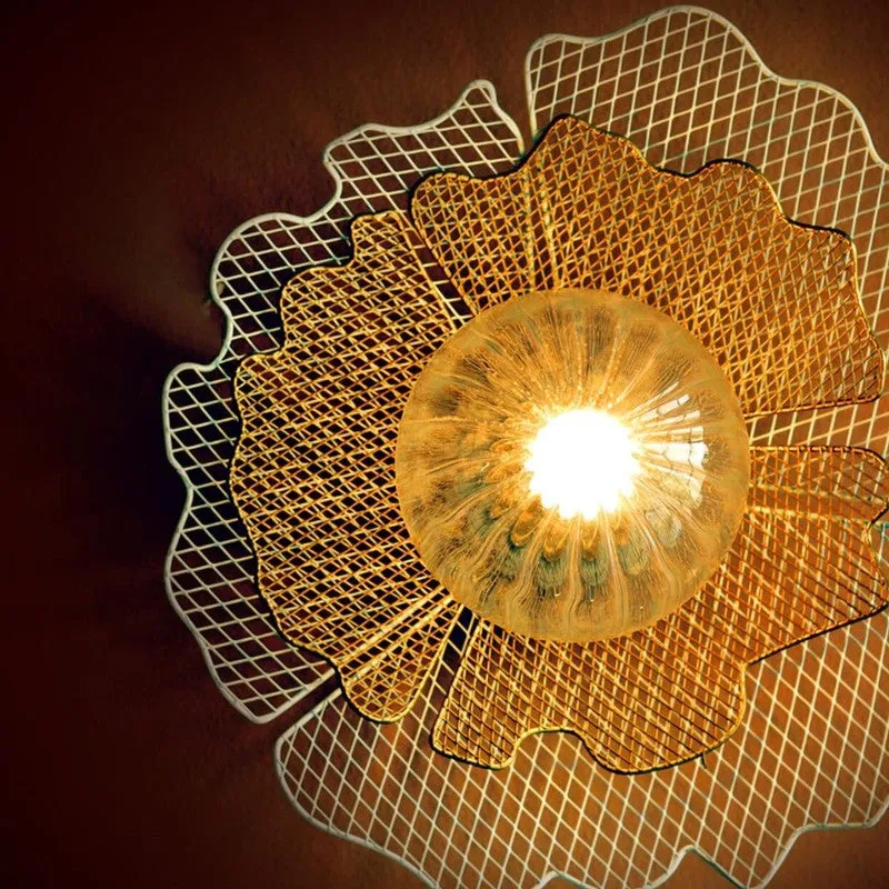 Close-up of glowing ribbed glass shade on floral wall lamp