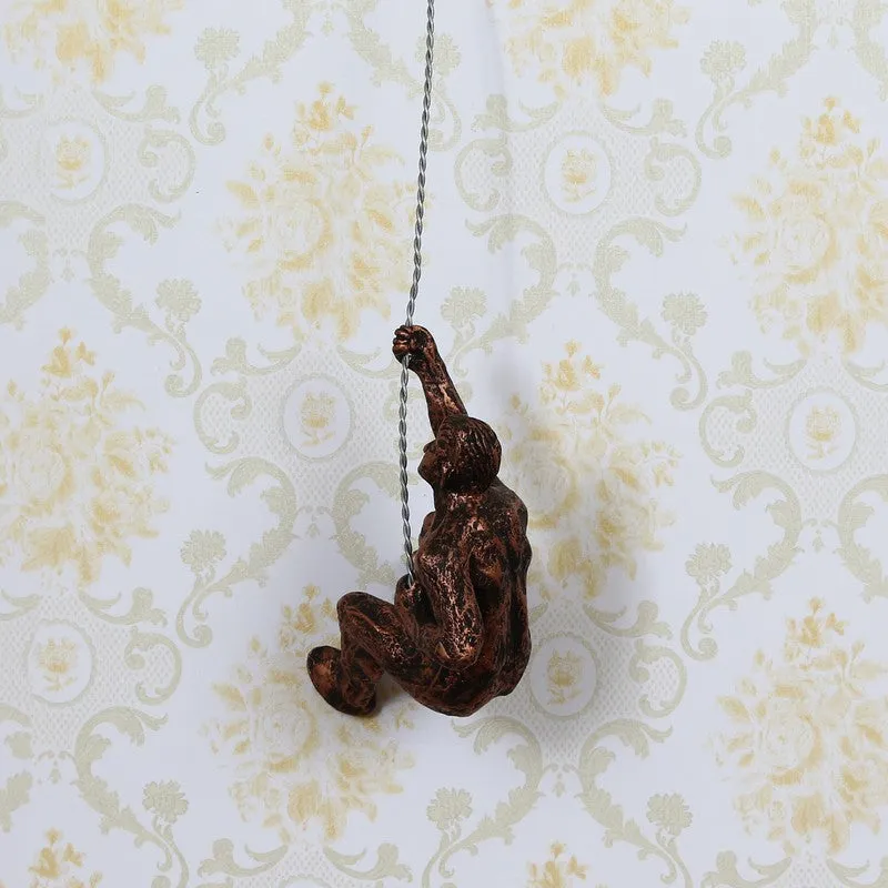 Bronze climbing figure wall accent shown hanging on patterned wall