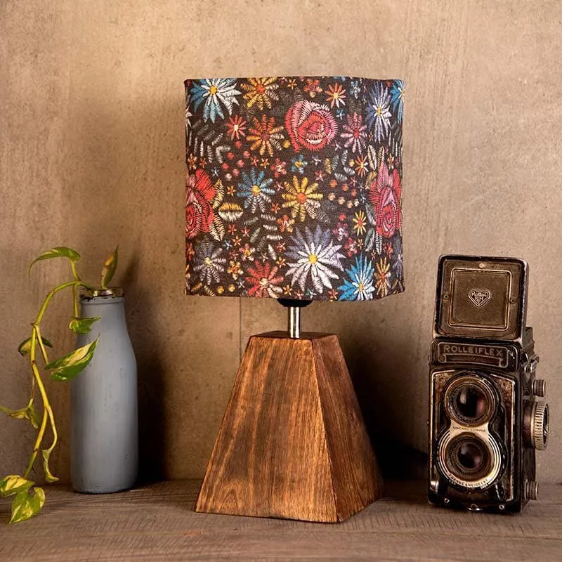 Multicolour floral table lamp with brown base styled on a wooden surface