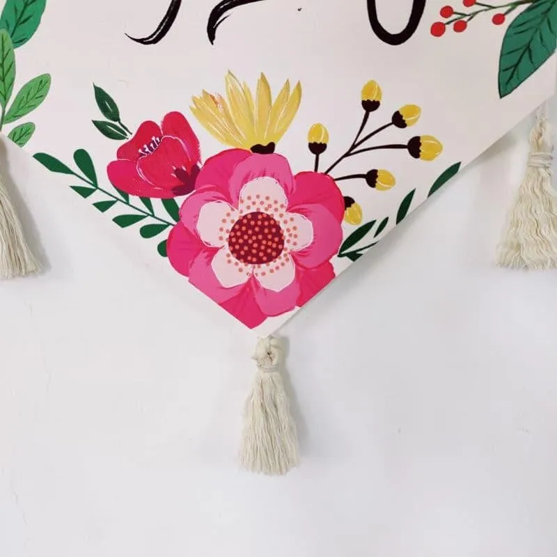 Close-up of floral detail and tassel on the canvas wall hanging