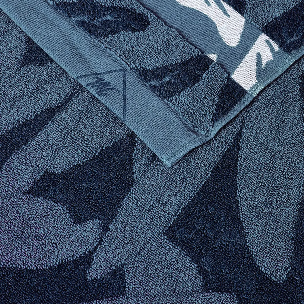 Detailed view of the blue floral towel weave and finished edge