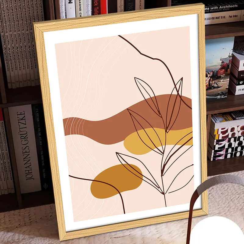 Framed abstract botanical print with earthy tones styled against a bookshelf