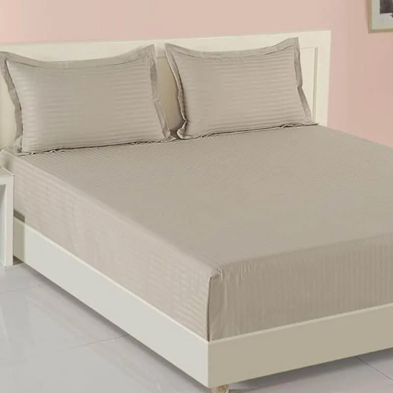 Close view of a beige striped bedsheet with matching pillow covers