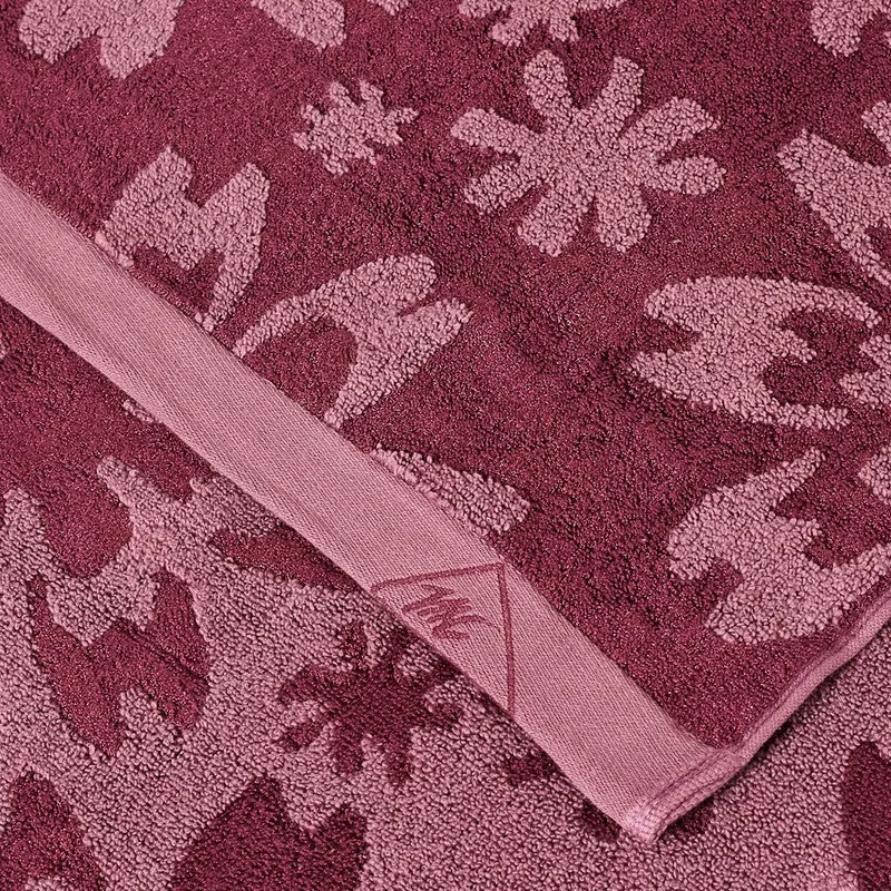 Detailed view of the maroon and pink floral towel texture and finished border.