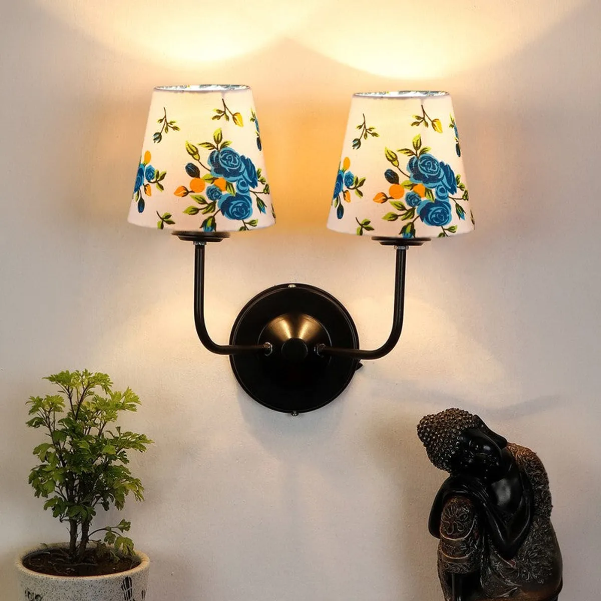Twin wall lamp with white shades and black iron base on a wall