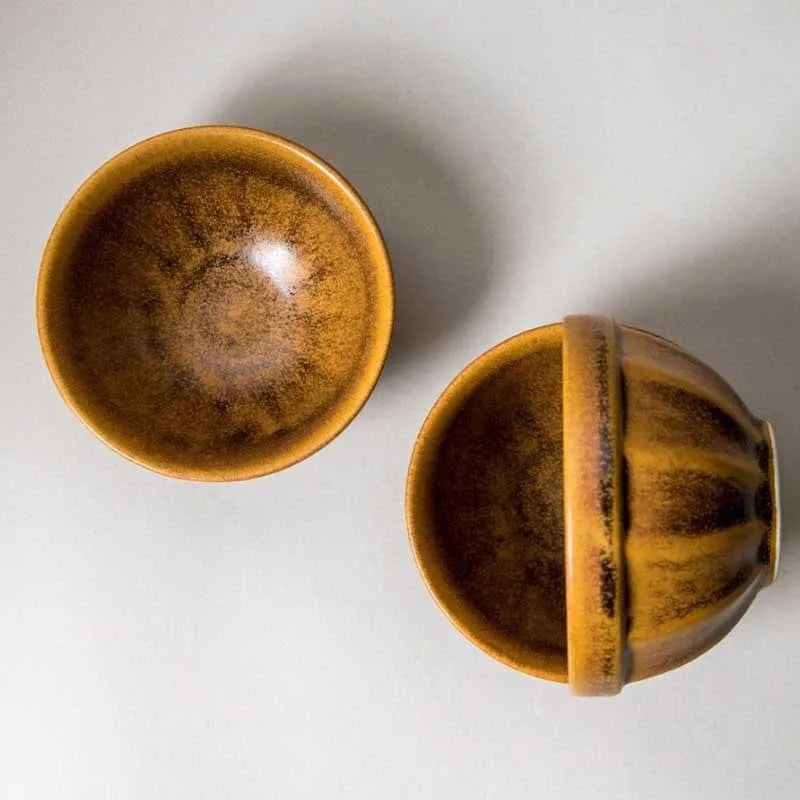 Top view of two round brown snack bowls showing their glossy interiors