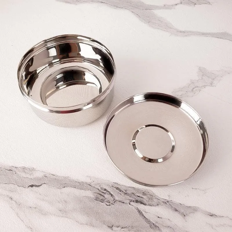 Open silver storage container beside its round lid