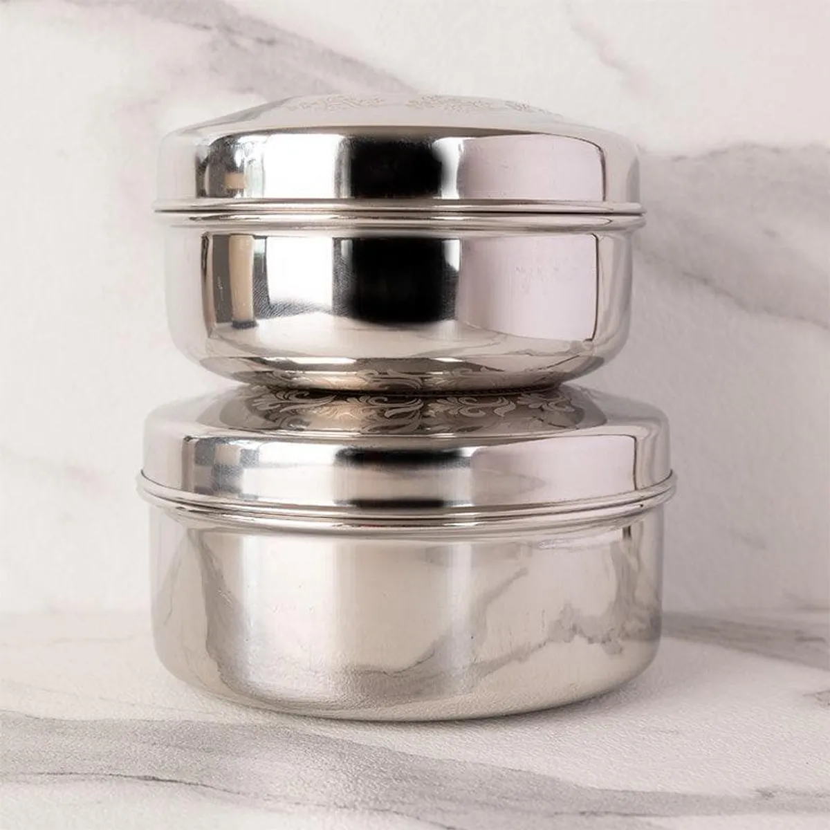 Two silver storage containers stacked one above the other