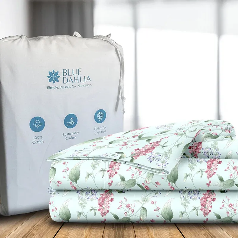 Folded aqua floral bedding displayed beside a storage bag.