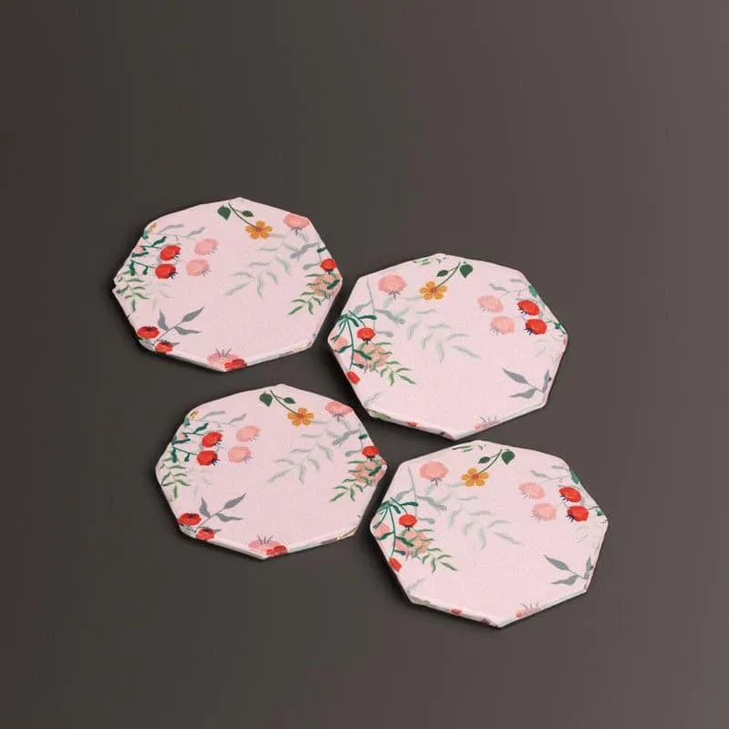 Four floral octagonal coasters arranged on a dark background