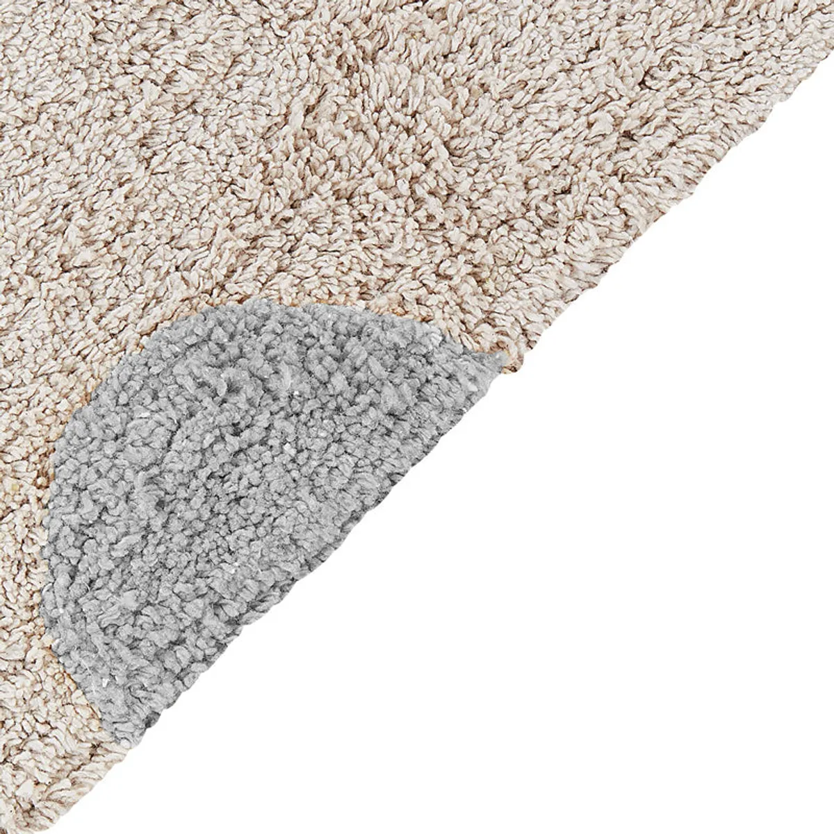 Close-up of the rug's soft textured surface and grey polka dot detail