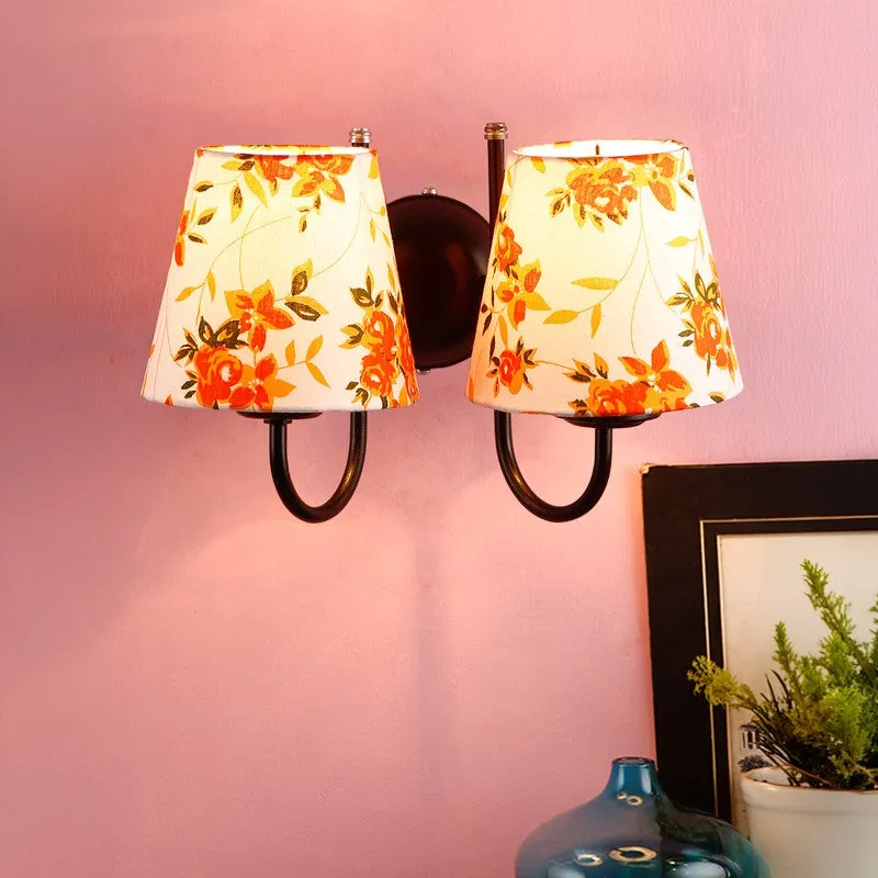 Orange floral cotton wall lamp with two shades on a pink wall