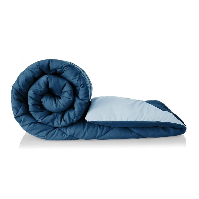 Rolled blue and pale teal reversible comforter shown against a white background