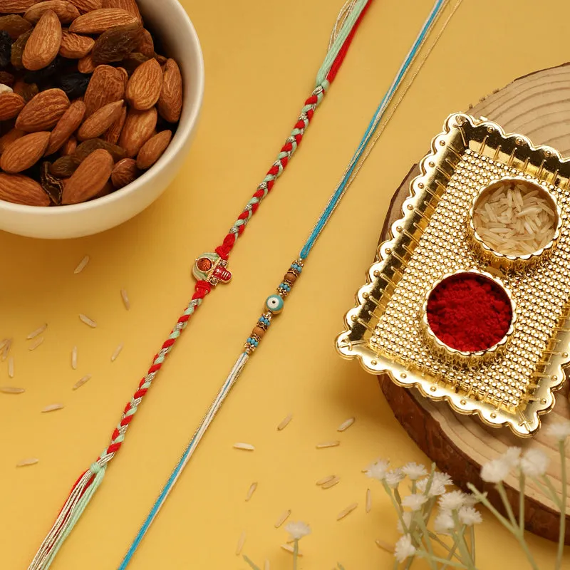 Two colourful rakhis beside a gold-toned pooja tray on a yellow background
