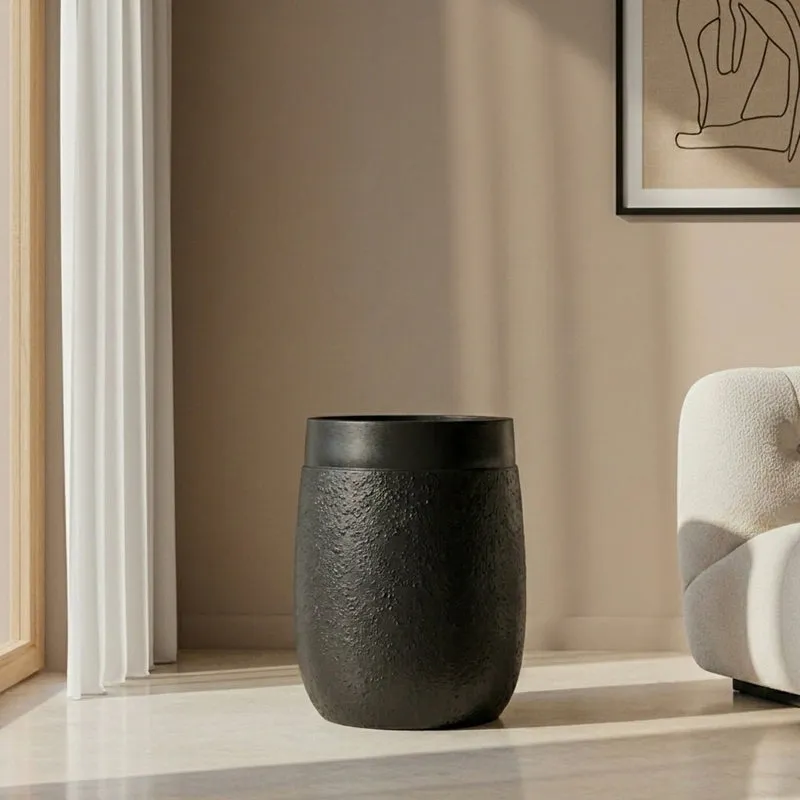 Black cylindrical planter with a matte finish in a bright living room