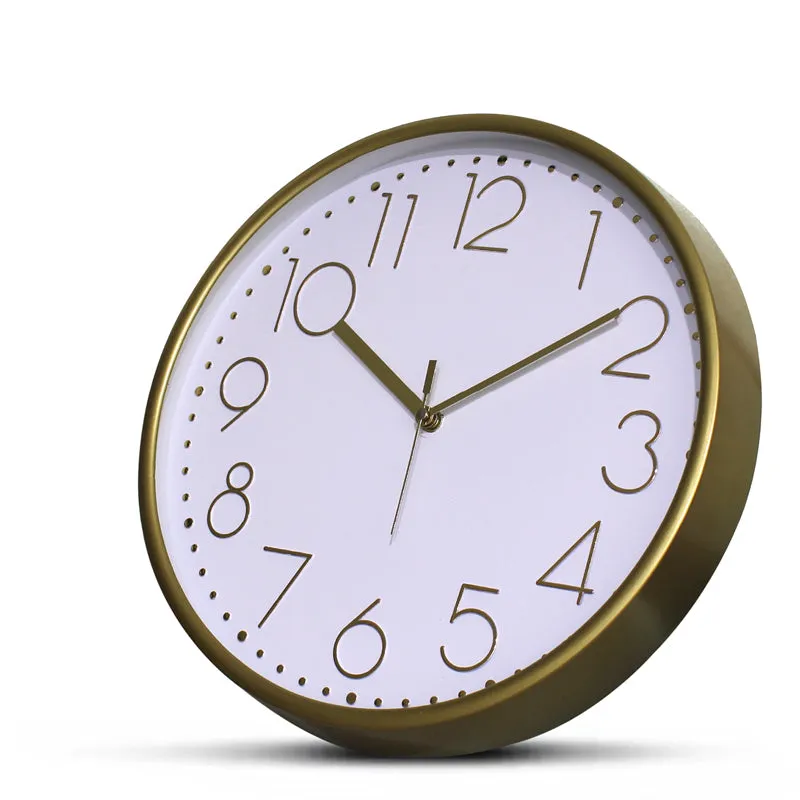Angled view of a round gold and white wall clock on a plain background